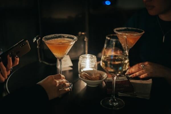 Martini glasses in a dark room lit by a candle
