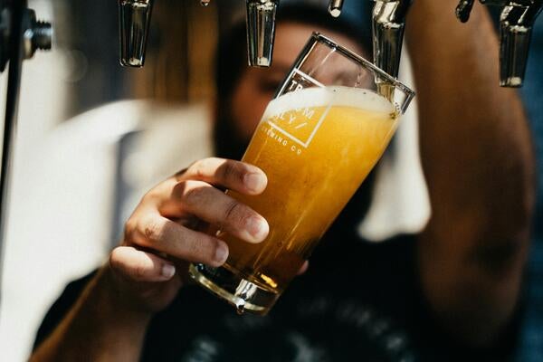 Person holding a glass of beer