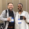 Attendees smiling at the camera with their UC Tech-themed mugs.