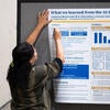 Poster presenter setting up their poster.