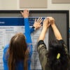 Poster presenters setting up their poster.
