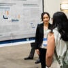 Poster presenter talking to an attendee about their poster.