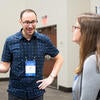 Poster presenter talking to an attendee about their poster.