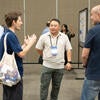 Poster presenter talking to attendees about their poster.
