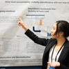 Poster presenter talking to attendees about their poster.