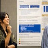 Poster presenter talking to attendees about their poster.