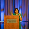 Conference emcee, Azra Ayers, speaking at the podium.