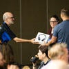 Sponsor representative and volunteer handing out a raffle prize to a winning attendee.