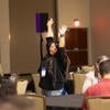 Attendee happily raising their arms up after winning a raffle prize.