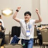 Attendee happily raising their arms up after winning a raffle prize.