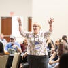 Attendee happily raising their arms up after winning a raffle prize.