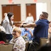 Attendees happily raising their arms up after winning a raffle prize.