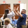 Attendee happily raising their arms up after winning a raffle prize.