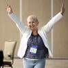 Attendee happily raising their arms up after winning a raffle prize.